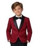 A young boy modeling a formal kids' tuxedo featuring a textured red velvet blazer with black satin lapels, black trousers, a white dress shirt, and a black bow tie, set against a plain white studio background.