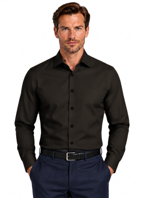 A man wearing a black long-sleeve button-down dress shirt with navy blue trousers and a black belt, photographed against a solid white background.