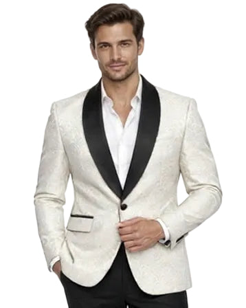A man modeling a white tuxedo jacket with black satin lapels, paired with black trousers and brown dress shoes, standing against a solid white background.