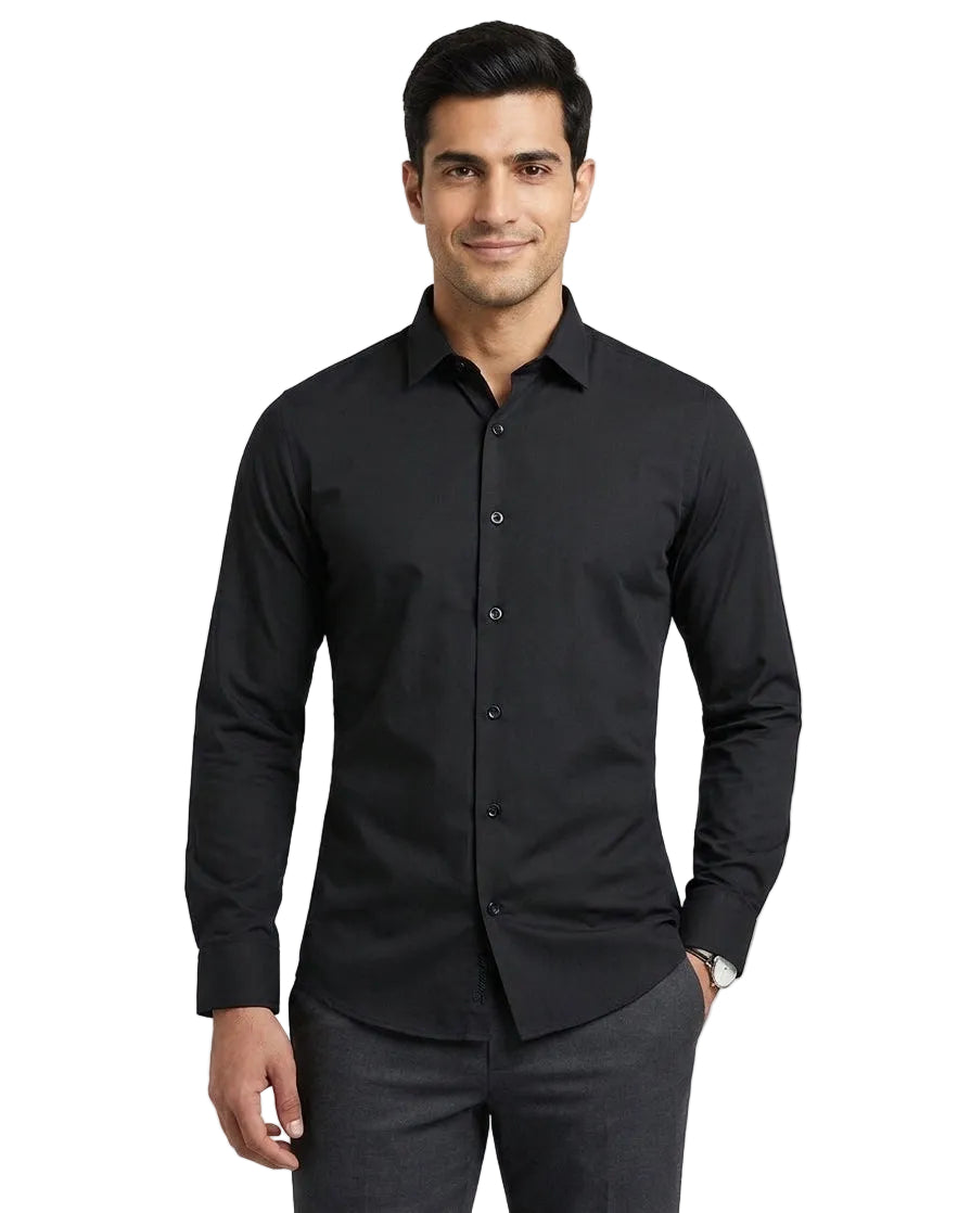 A man wearing a black long-sleeve button-down dress shirt and dark gray trousers, standing against a light gray studio background.