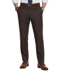 A man modeling a light blue dress shirt, navy tie, dark brown trousers, a brown belt, and brown leather dress shoes against a plain white studio background.