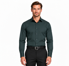 Load image into Gallery viewer, A man wearing a dark forest green long-sleeve button-down dress shirt with black trousers and a black belt, standing against a plain white background.