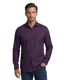 A man wearing a long-sleeve button-down shirt in a deep purple color, paired with dark blue jeans, standing against a plain white background.